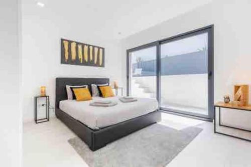 a bedroom with a bed and a large window at Tequila House - Luxury House in Portugal in Mariquiteira