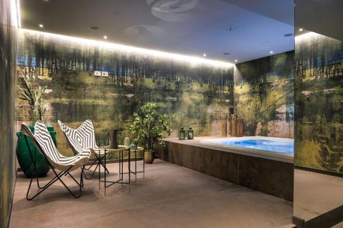 a bathroom with a tub with two chairs and a table at Palazzo Sangiorgio in Catania