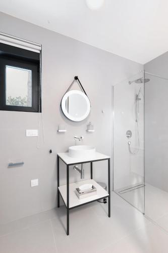a white bathroom with a sink and a mirror at Villa XeMa in Dramalj