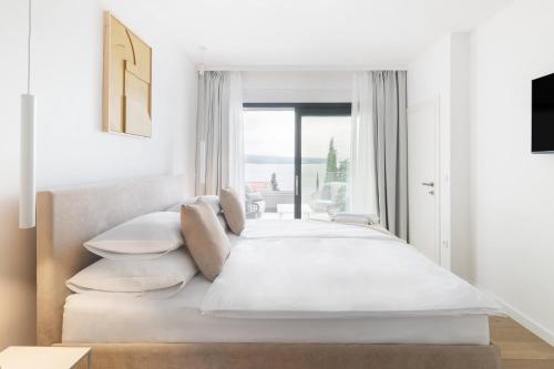1 dormitorio blanco con 1 cama grande y ventana en Villa XeMa, en Dramalj
