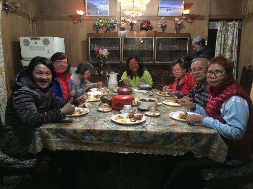 a group of people sitting around a table eating food at New Sea Palace Houseboats in Srinagar
