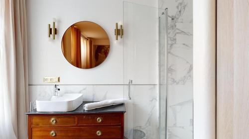 une salle de bain avec un lavabo et un miroir dans l'établissement Bluestay 115 - Superbe Appartement à Paris, à Paris