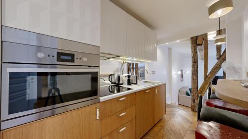 La cuisine est équipée d'un grand four et d'un évier. dans l'établissement Bluestay 115 - Superbe Appartement à Paris, à Paris