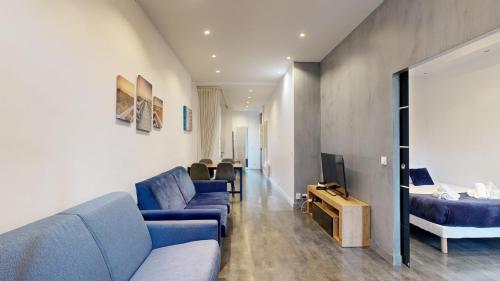 un salon avec des canapés bleus et une télévision dans l'établissement Bluestay 63 - Appartement cozy, Paris centre, à Paris