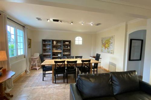 un salon avec un canapé, une table et des chaises dans l'établissement Maison familiale 200 m de la mer, à Denneville-Plage