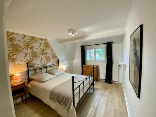 une chambre avec un grand lit et une fenêtre dans l'établissement Maison familiale 200 m de la mer, à Denneville-Plage