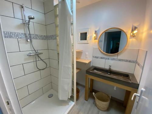 une salle de bain avec une douche, un lavabo et un miroir dans l'établissement Maison familiale 200 m de la mer, à Denneville-Plage