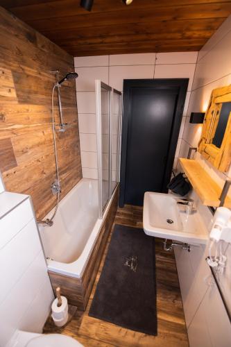 a bathroom with a tub and a sink and a shower at Mountainlodge Tirol Berwang in Berwang