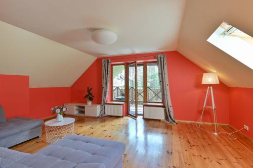 a living room with red walls and a couch at House with sauna and jacuzzi in Jūrmala