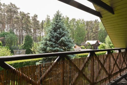 a christmas tree on a deck with a fence at House with sauna and jacuzzi in Jūrmala
