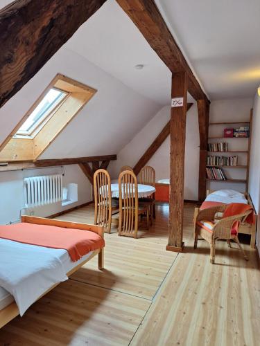 a attic room with two beds and a table and chairs at Folwark in Stronie Śląskie