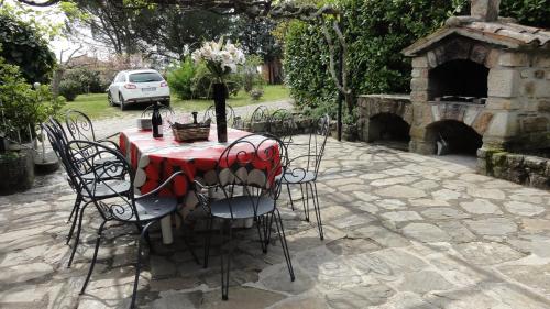 a table with chairs and a table with a vase with flowers at Gîte La Jaujon in Lablachère