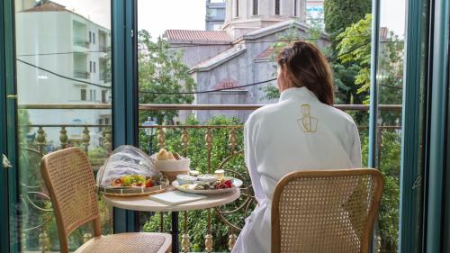 a woman standing on a balcony with a table with food at Juan Rodriguez Hacienda in Athens