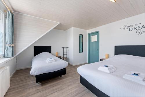 a bedroom with two beds and a staircase at Ruime woning aan zee met zonnige tuin en terras - 9p in Blankenberge