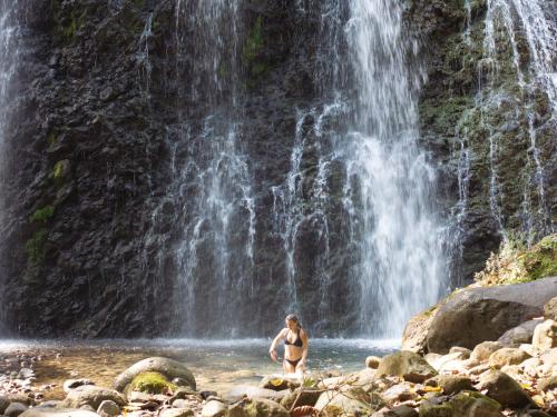 a woman standing in the water in front of a waterfall at Panama Kite Center in Punta Chame