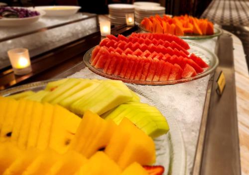 three trays of fruit on plates on a counter at One World Hotel in Petaling Jaya