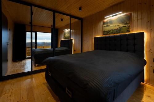 a bedroom with a bed and a large window at Sunset Hill Chalet Sighișoara in Sighişoara