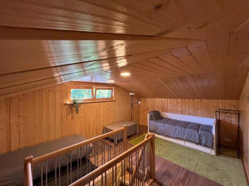 a room with a bed in a wooden room at Cozy Forest Cabin in Kadaga