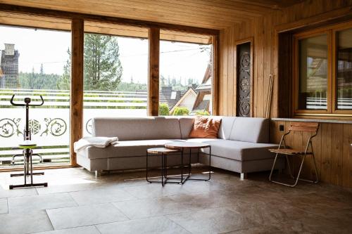 ein Wohnzimmer mit einer Couch und einigen Fenstern in der Unterkunft Willa Dziubas II in Zakopane