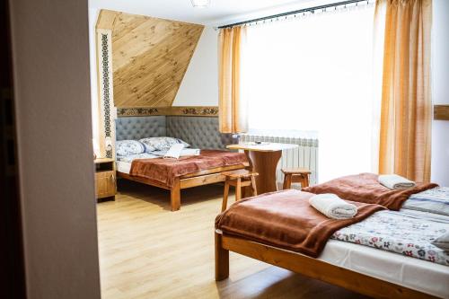 ein Schlafzimmer mit zwei Betten und einem Fenster in der Unterkunft Willa Dziubas II in Zakopane