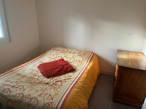 - un lit avec un oreiller rouge dans l'établissement Location Chambre, à Villefranche-du-Queyran
