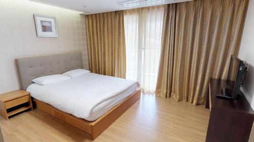 a hotel room with a bed and a television at High1 Condominium in Jeongseon