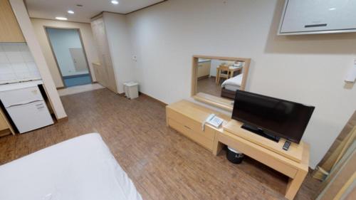 a bedroom with a bed and a tv and a mirror at High1 Condominium in Jeongseon