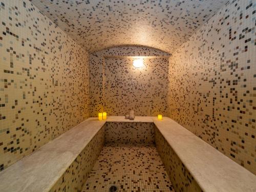 a room with two candles in a room with tiled walls at Elektra Hotel & Spa in Kalamata