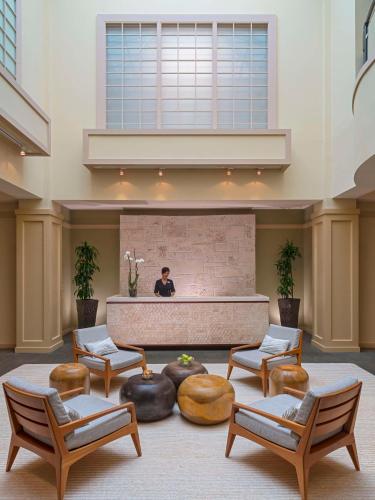 a man sitting in a large room with chairs and a fountain at Hyatt Regency Coconut Point Resort & Spa Near Naples in Bonita Springs