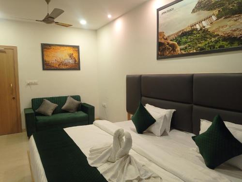 a bedroom with a bed and a green couch at Sun Stone Hotel & Club - Jawai in Sheoganj