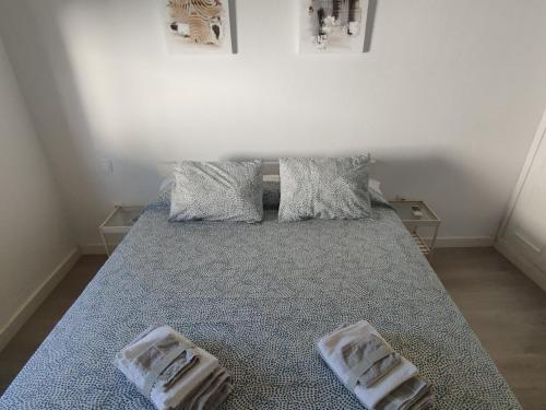 a bedroom with a bed with two towels on it at Casa Adosada Mirador de Sevilla in Tomares