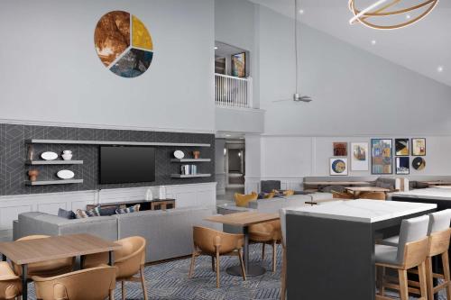 a restaurant with tables and chairs and a tv at Homewood Suites by Hilton Raleigh-Durham Airport at RTP in Durham