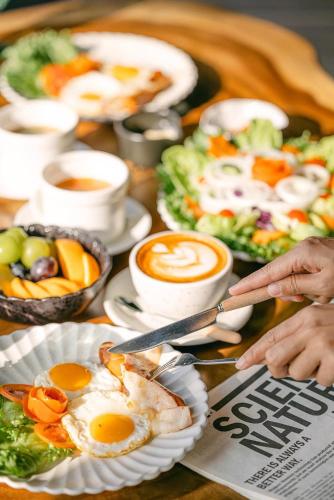 a table topped with plates of eggs and salad at รีสอร์ท มอร์เม้าเท่น ดอยช้าง in Ban Thao Kaen Chan