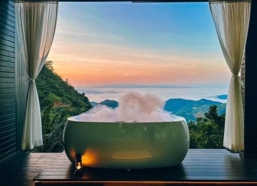 a bath tub filled with water in front of a window at รีสอร์ท มอร์เม้าเท่น ดอยช้าง in Ban Thao Kaen Chan