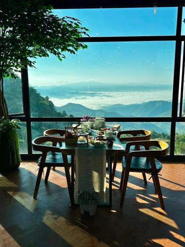 a table and chairs on a balcony with a view at รีสอร์ท มอร์เม้าเท่น ดอยช้าง in Ban Thao Kaen Chan