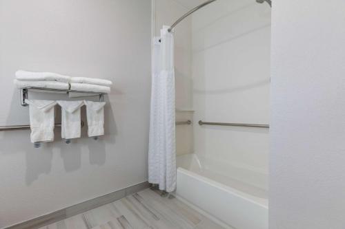 a bathroom with a shower and a bath tub with towels at Comfort Suites Lombard - Addison in Lombard