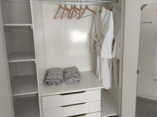 a walk in closet with white cabinets and hangers at Casa Adosada Mirador de Sevilla in Tomares
