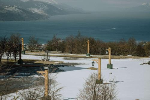 a snow covered field with a body of water at Wyndham Garden Ushuaia Hotel del Glaciar in Ushuaia