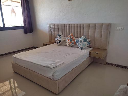 a bedroom with a large bed with pillows on it at Lina Village in Al Hachlaf