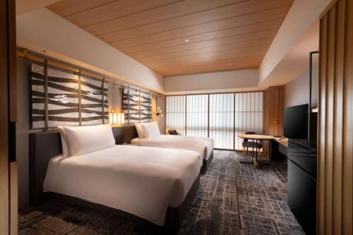 a hotel room with two beds and a television at Hilton Kyoto in Kyoto