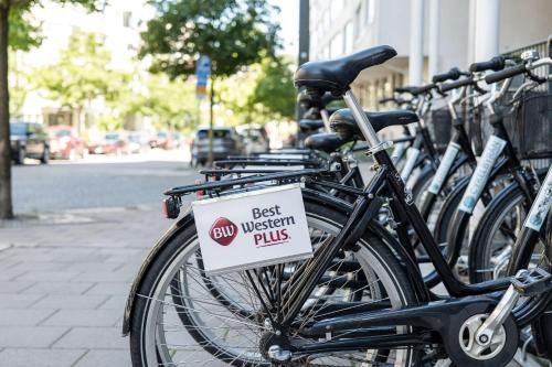 a row of bikes parked on a street with a best western plus sign at Best Western Plus Park City Hammarby Sjöstad in Stockholm