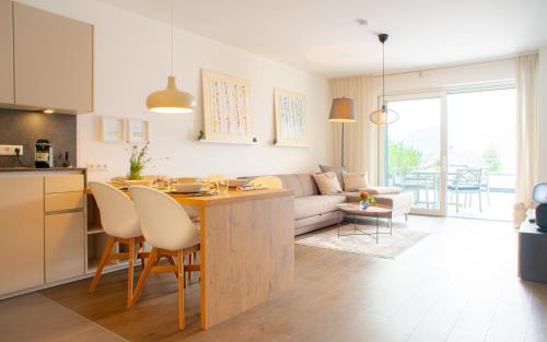 a kitchen and living room with a table and a couch at Top 3 Alpe Maritima - Seetraum in Annenheim