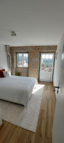 a bedroom with a large bed and a brick wall at Casa do Avô Xico in Sabugal