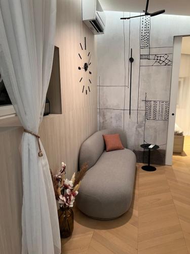 sala de estar con silla y reloj en la pared en Apartment Mirakul, en Šibenik