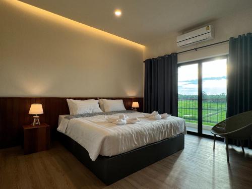 une chambre avec un grand lit et une grande fenêtre dans l'établissement Zenery Lake Resort, à Ban Don Klang