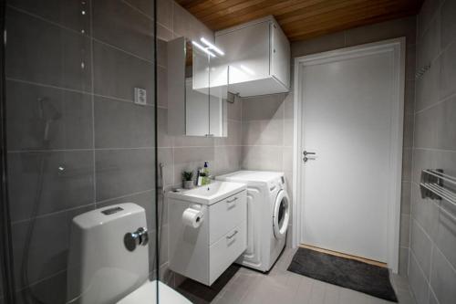 a bathroom with a toilet and a washing machine at Brand new studio apartment near the harbour in Turku