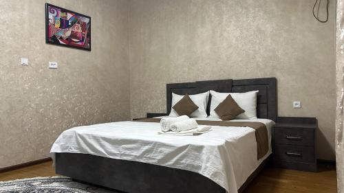 a bedroom with a bed with a black headboard at Sultan hotel boutique in Andizhan
