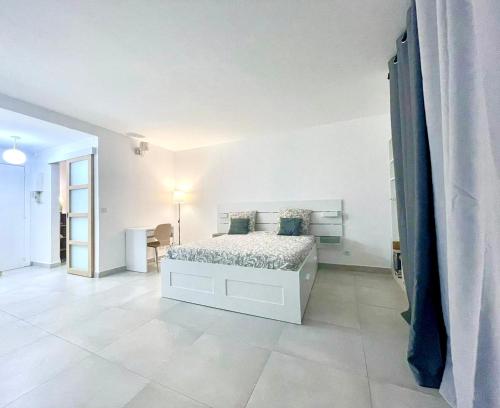 - une chambre blanche avec un lit dans l'établissement Le Petit Canotier, à Paris