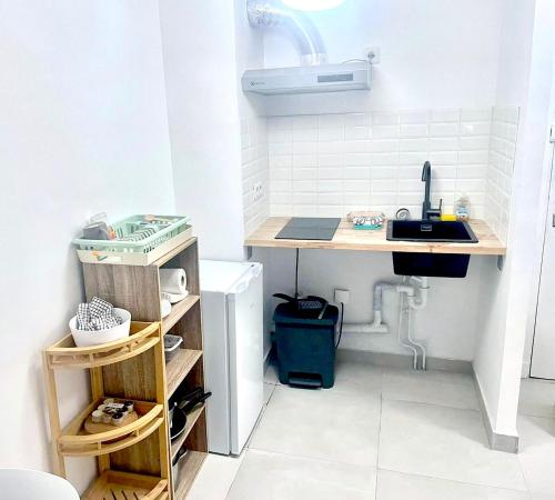 - une cuisine avec un bureau et un évier dans la chambre dans l'établissement Le Petit Canotier, à Paris