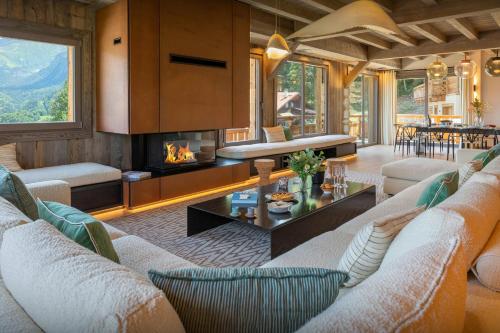 een woonkamer met banken en een open haard bij Chalet Mussol - OVO Network in Saint-Gervais-les-Bains